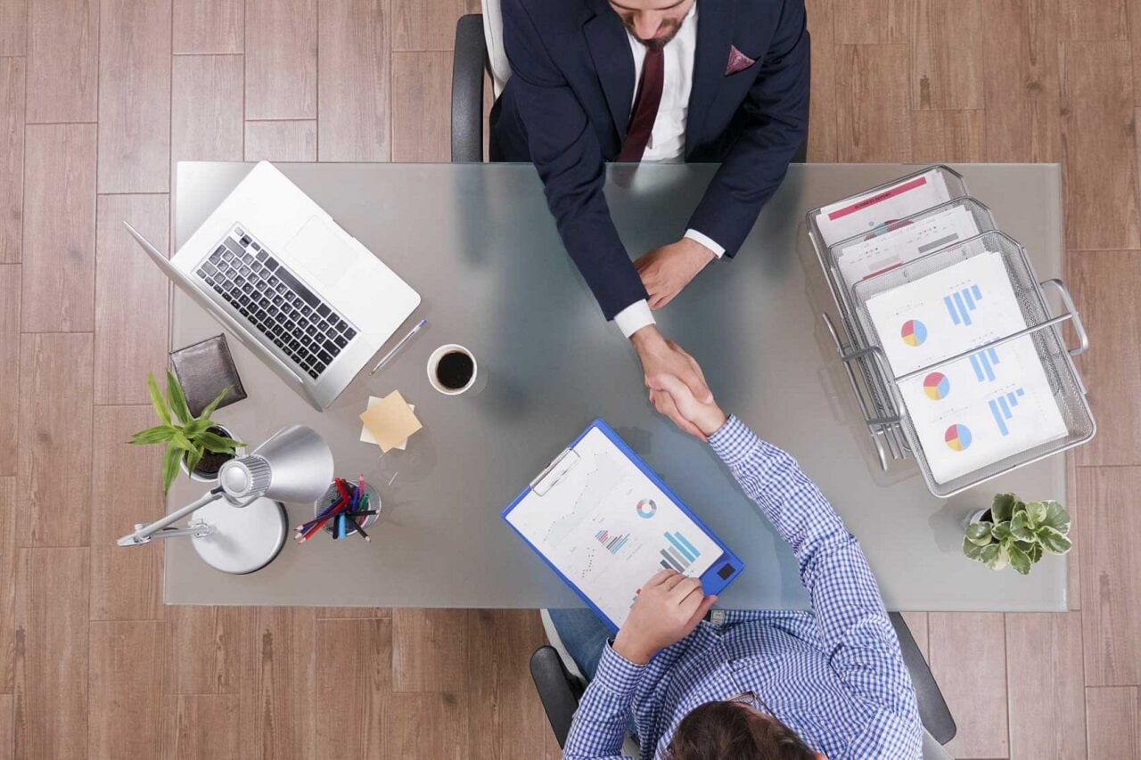 top-view-businessmen-shaking-hands-during-business-negotiation-startup-office
